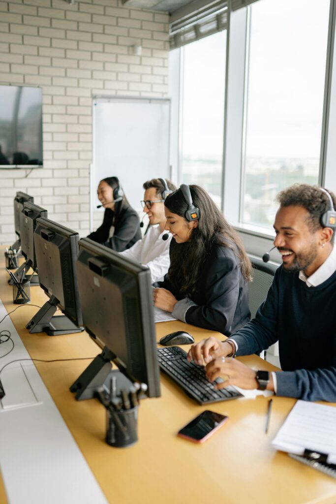 A diverse group of call center employees working together at desks in a modern office.